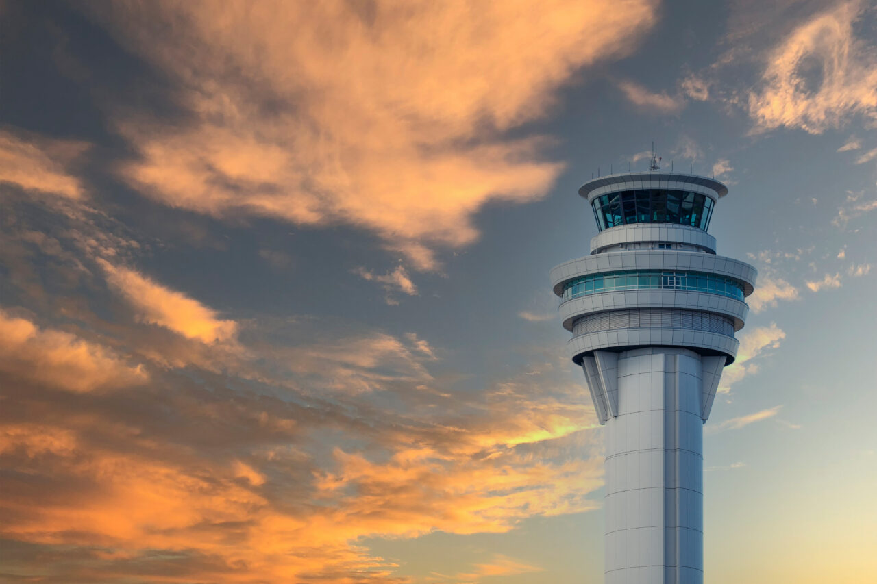 Air traffic control tower with a pink sky with light clouds